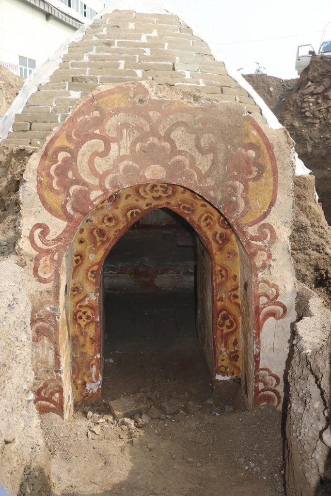 an arched entry painted in red and orange