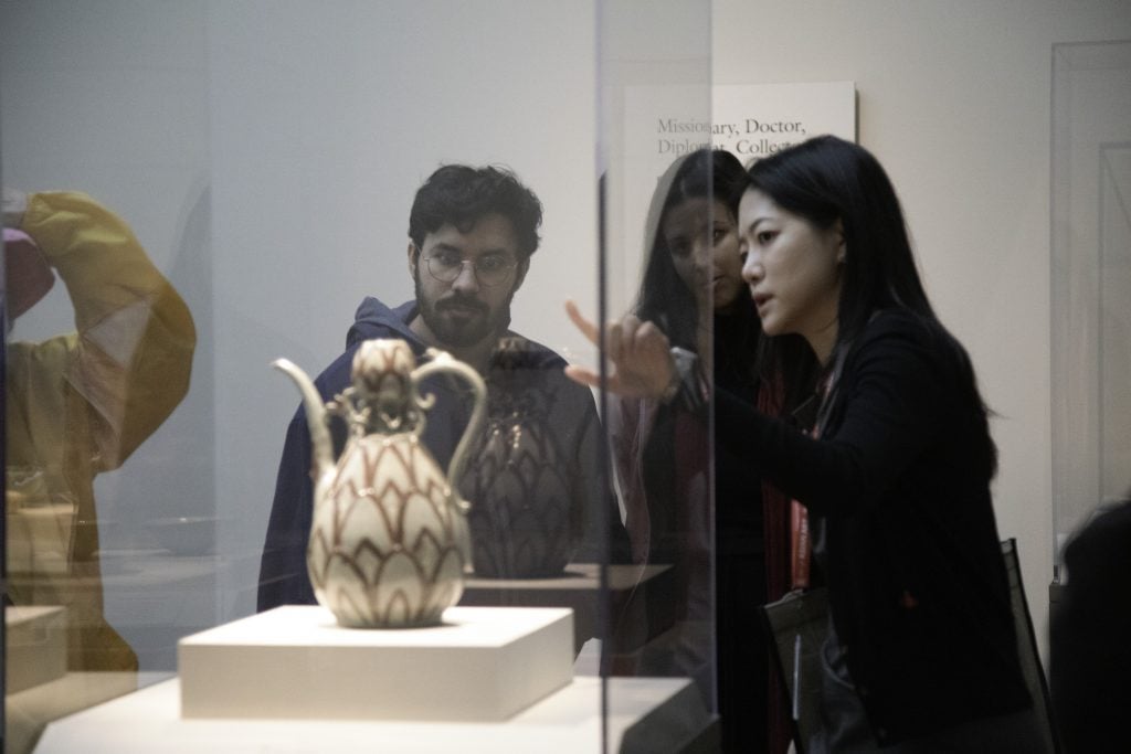 Visitors viewing an object in the Korean gallery. National Museum of Asian Art, Smithsonian Institution.