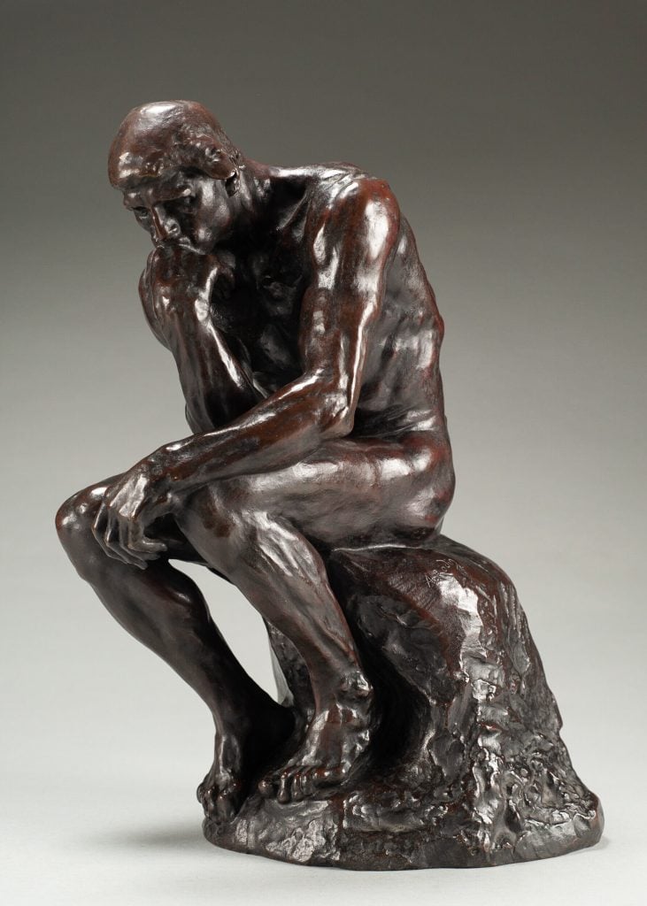 a sculpture of a man thinking, elbow on knee