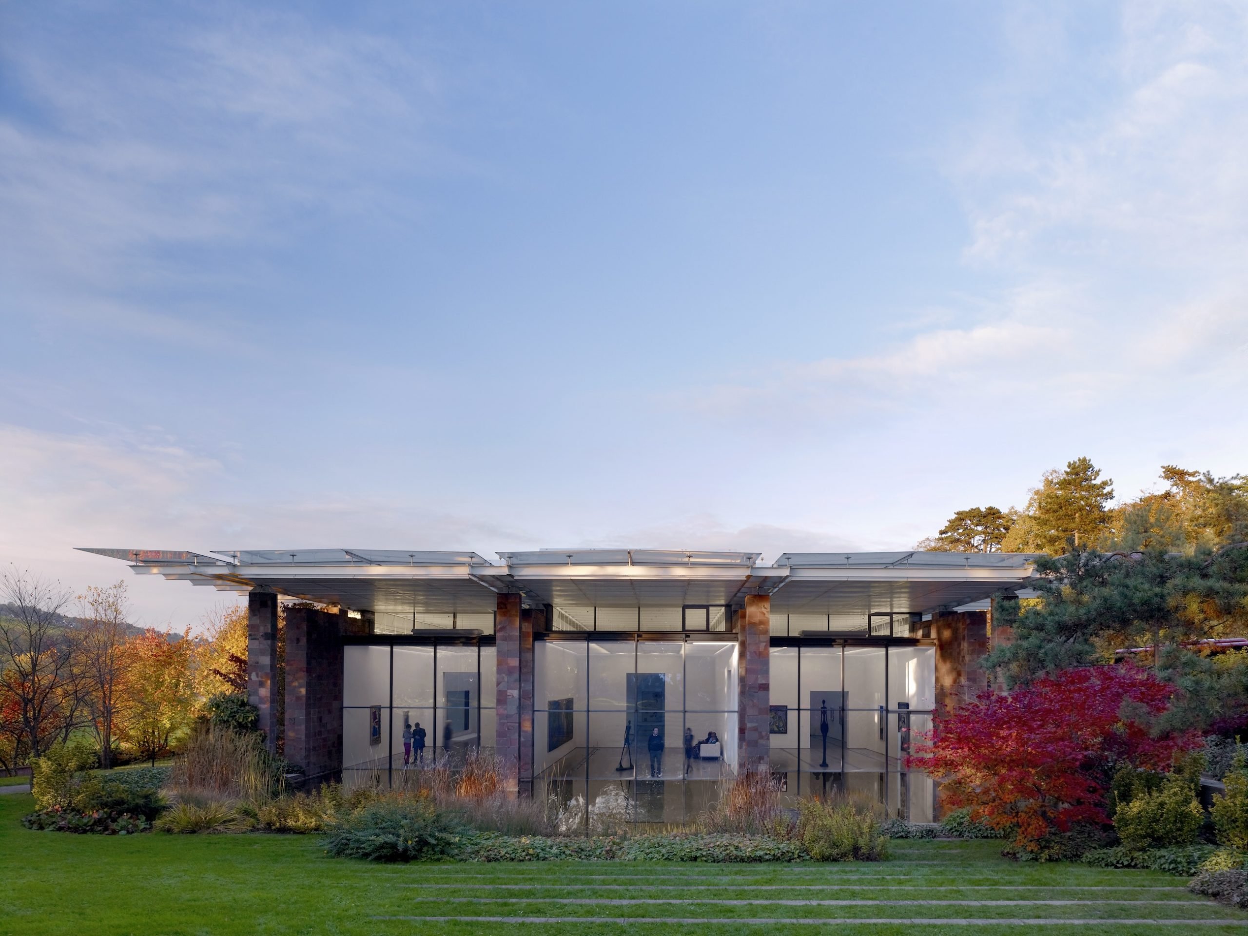 A modernist building in a lush green setting.