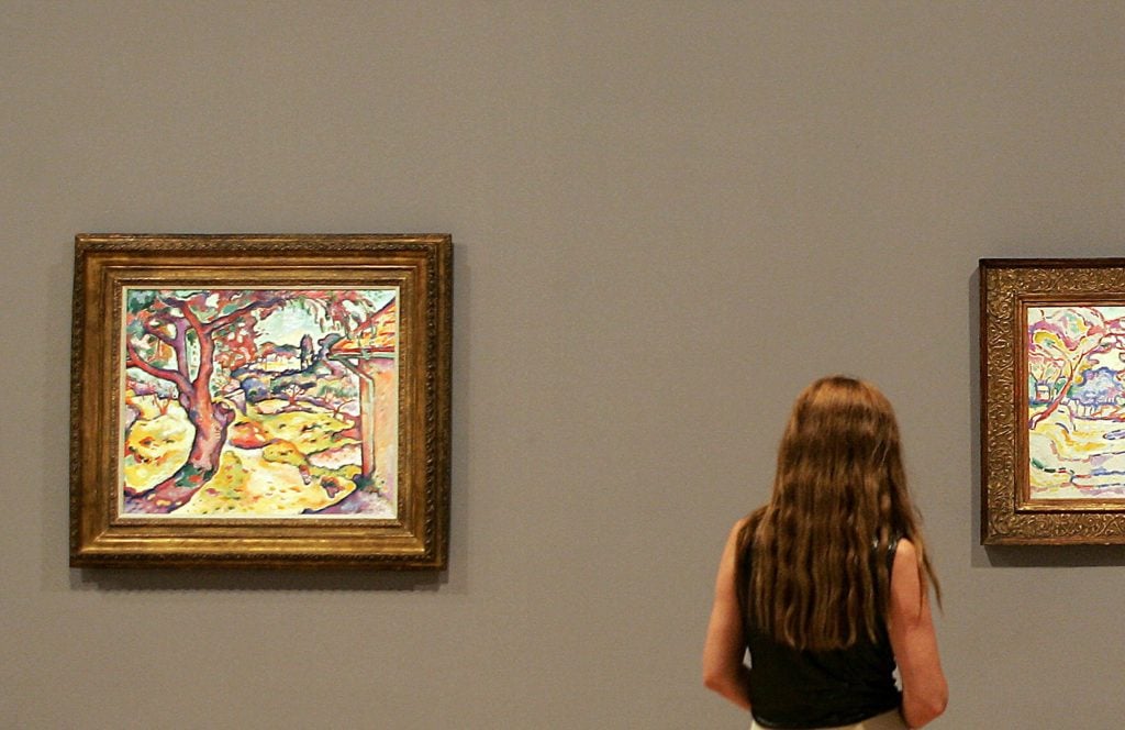 A woman looking at a colorful Georges Braque landscape in a gallery
