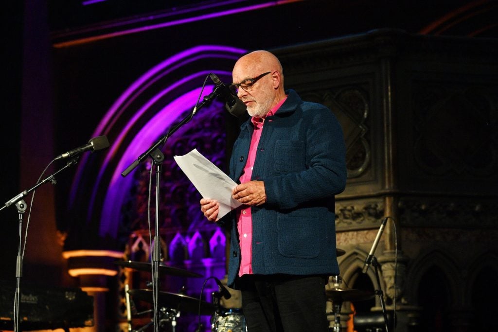 A man speaks into a mic onstage