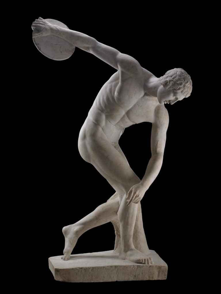 A marble Discobolus sculpture of a nude man in the midst of throwing a discus, looking at the ground.