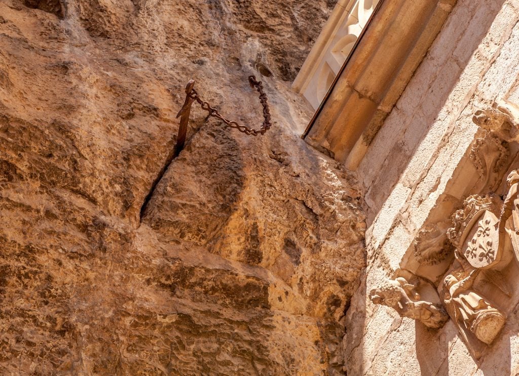 A sword sticking out of a stone wall