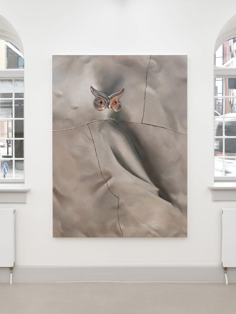 a massive painting of a silver bird on a white wall
