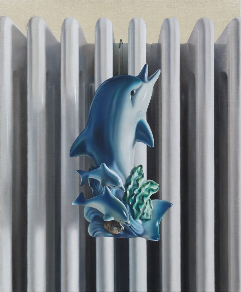 a painting of a dolphin medallion clipped to a radiator.