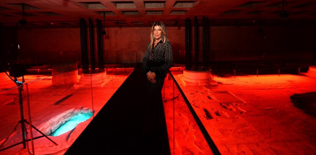 woman standing in an archeological installation