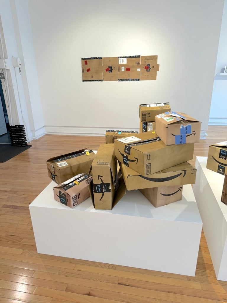 A pile of cardboard Amazon boxes displayed in a gallery