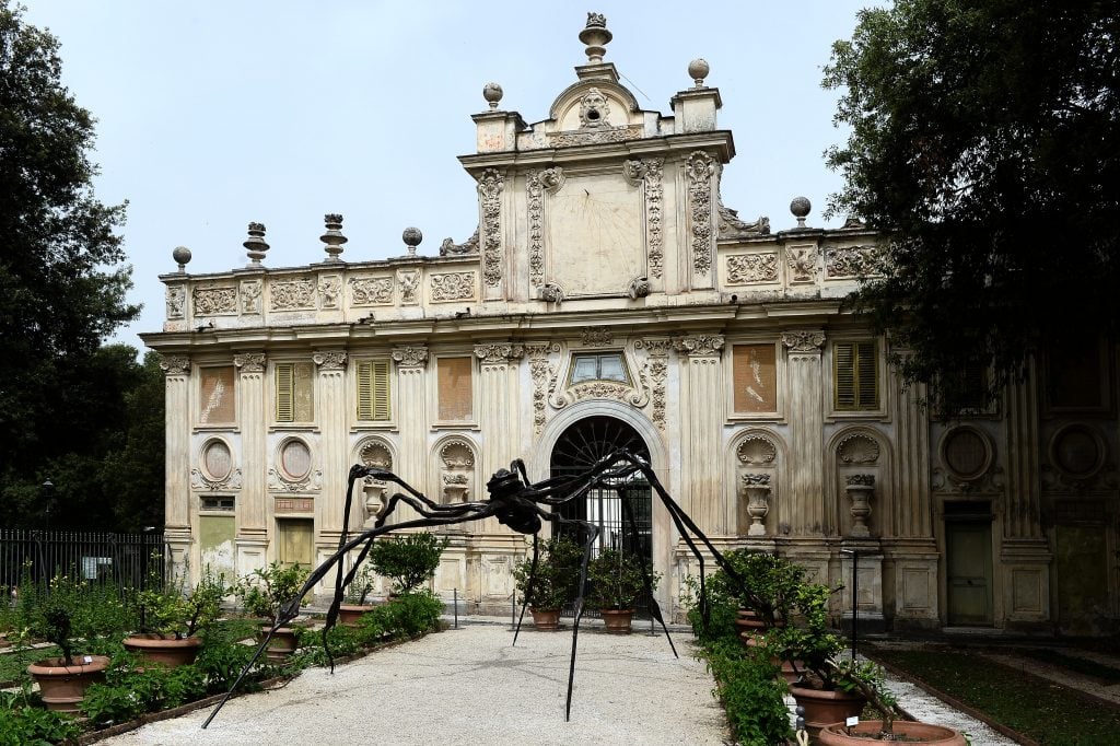 exterior of a classical building with a spider sculpture outside of it