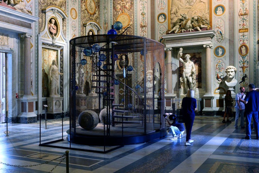 view of a classical building with a cage sculpture of contemporary art