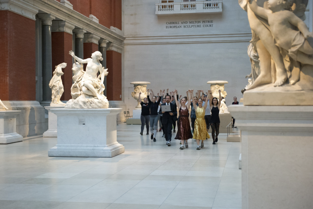 A group of people walks through a museum gallery.