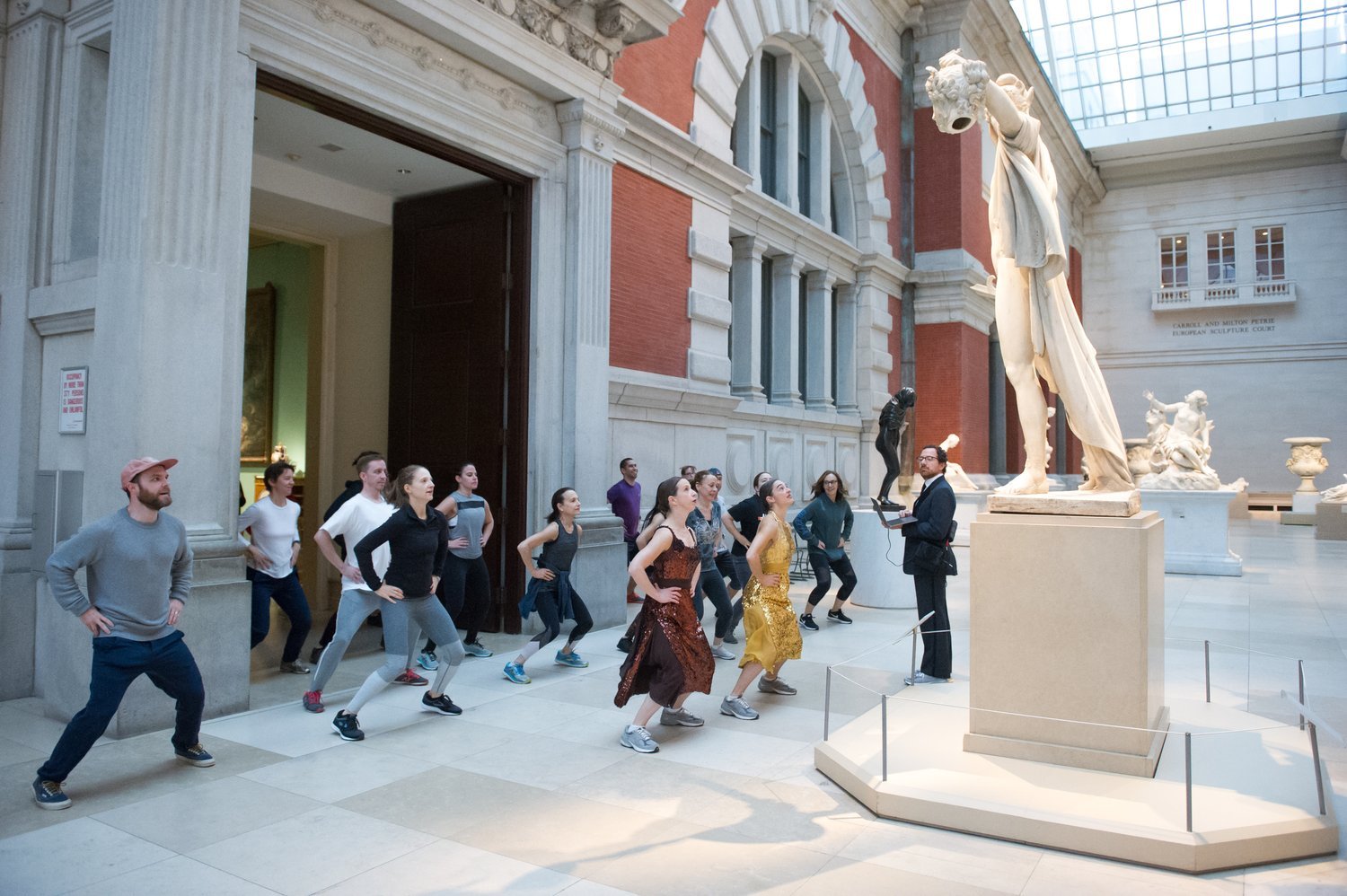 A group of people exercises in a museum gallery