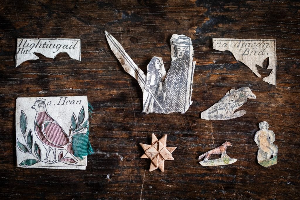 Old paper cutouts on a brown wooden surface