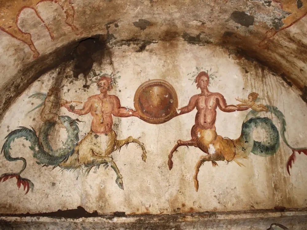 two mythical creatures with the bodies of men, legs of a horse, and sea creatures tails are found on an ancient tomb in italy