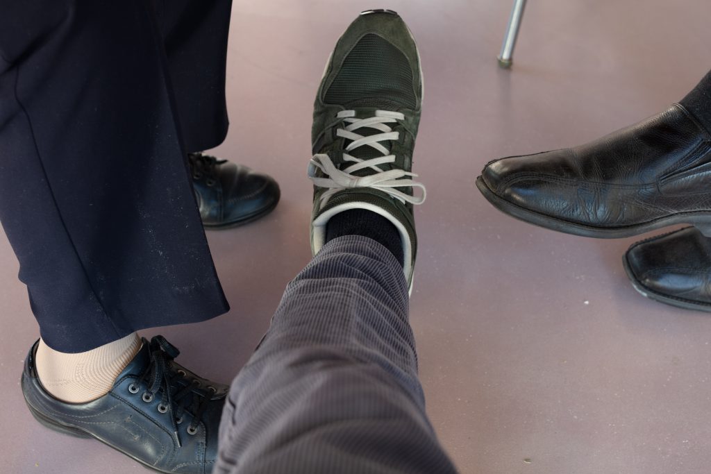 photograph of three people's feet in shoes