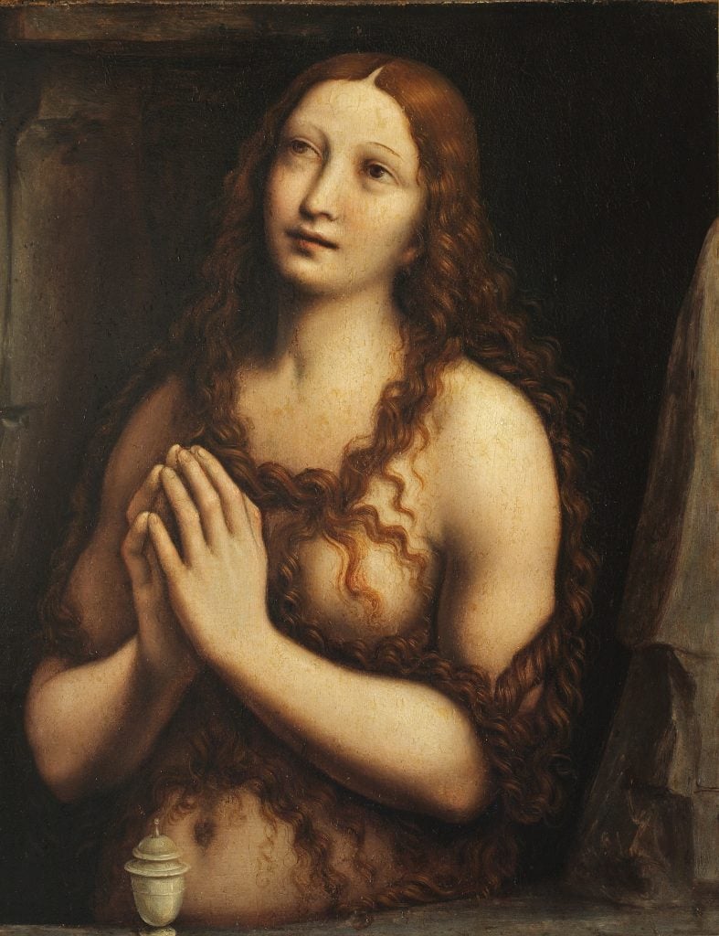 Portrait of a naked woman, her hands folded in prayer and her long hair falling over her chest. In front of her stands a small incense burner.