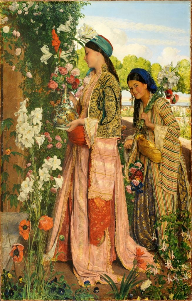 two women standing in a garden with flowers