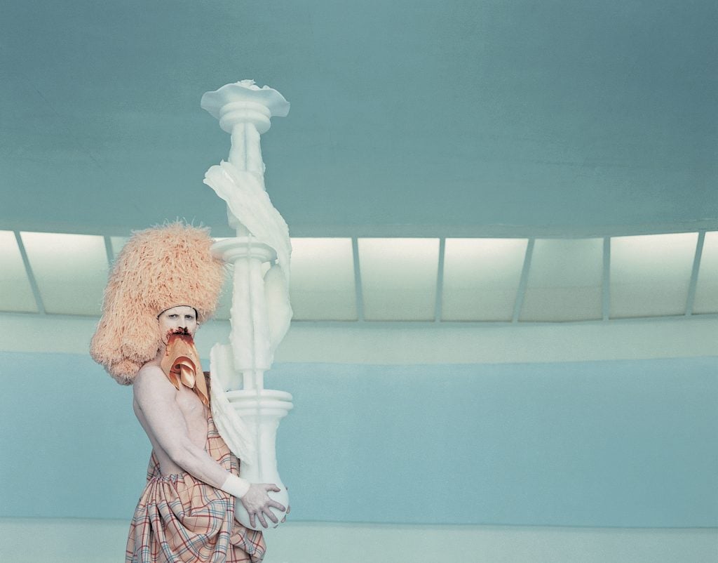 the artist Matthew Barney is painted white and costumed in pink regalia in a still from his art film cremaster 3