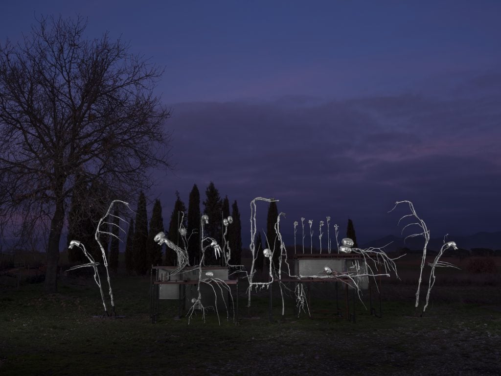 an installation of sculptures made with industrial materials set in the italian countryside
