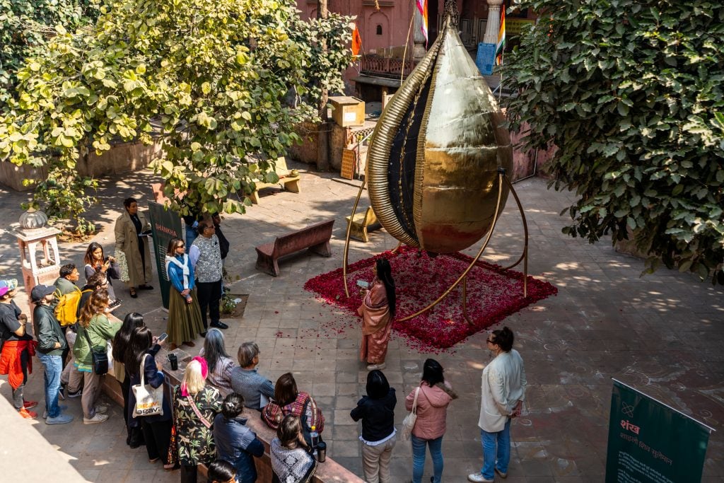 A big sculpture in gold on view in a garden