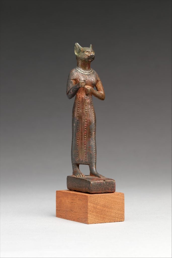 an Egyptian sculpture of a woman with the head of a cat