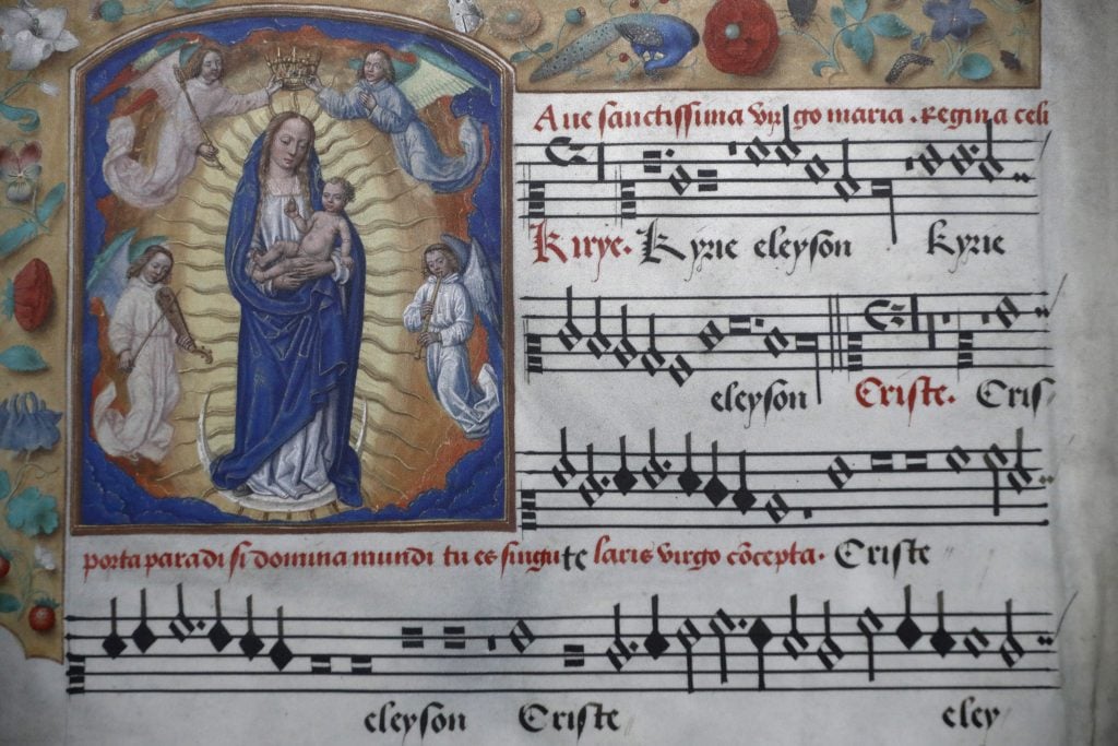 a piece of sheet music in a very medieval elaborate style with a border of floral motifs