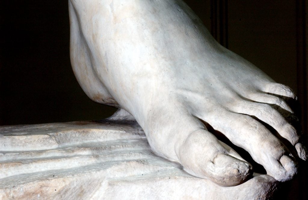a close up photograph of the marble foot of michelangelo's david sculpture