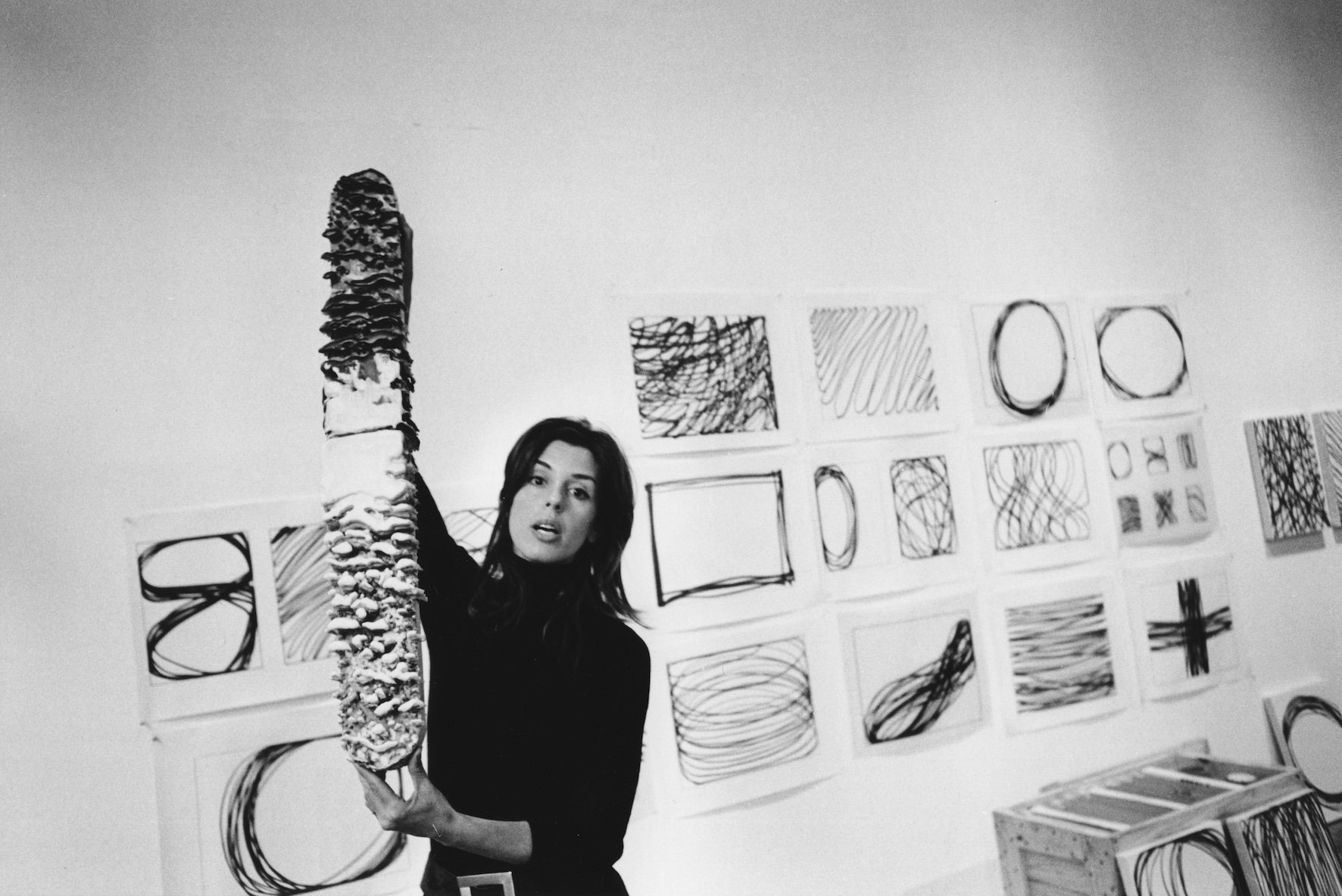 a young gallery owner with an abstract ceramic piece