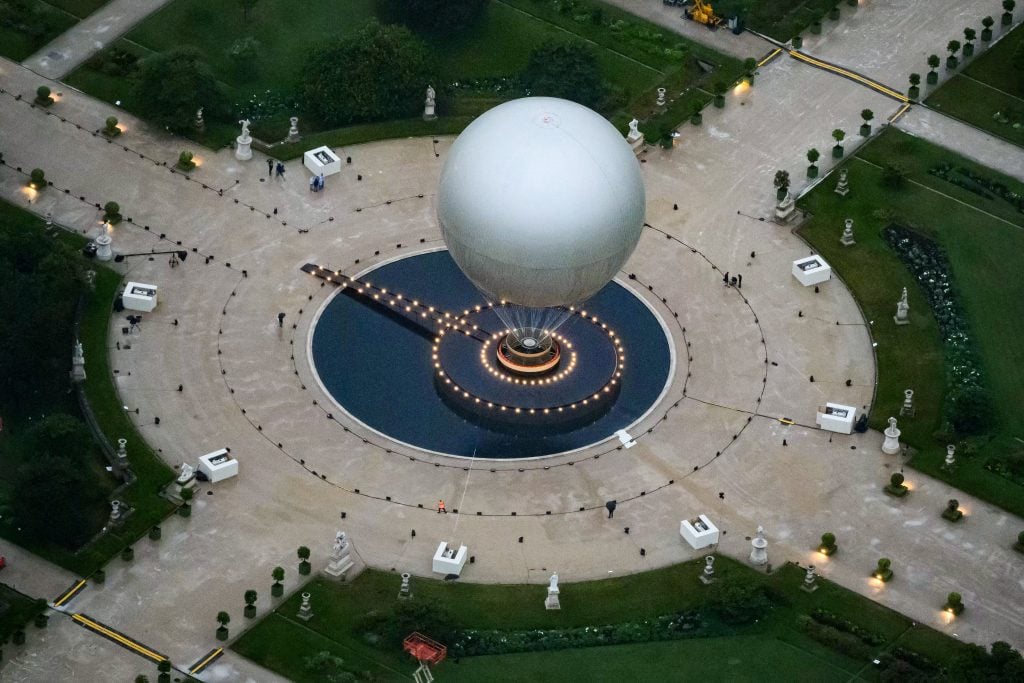 A photograph taken from a helicopter shows an aerial view of Mathieu Lehanneur's Olympic cauldron, which is suspended from a giant air balloon, in the Tuileries garden in Paris. 