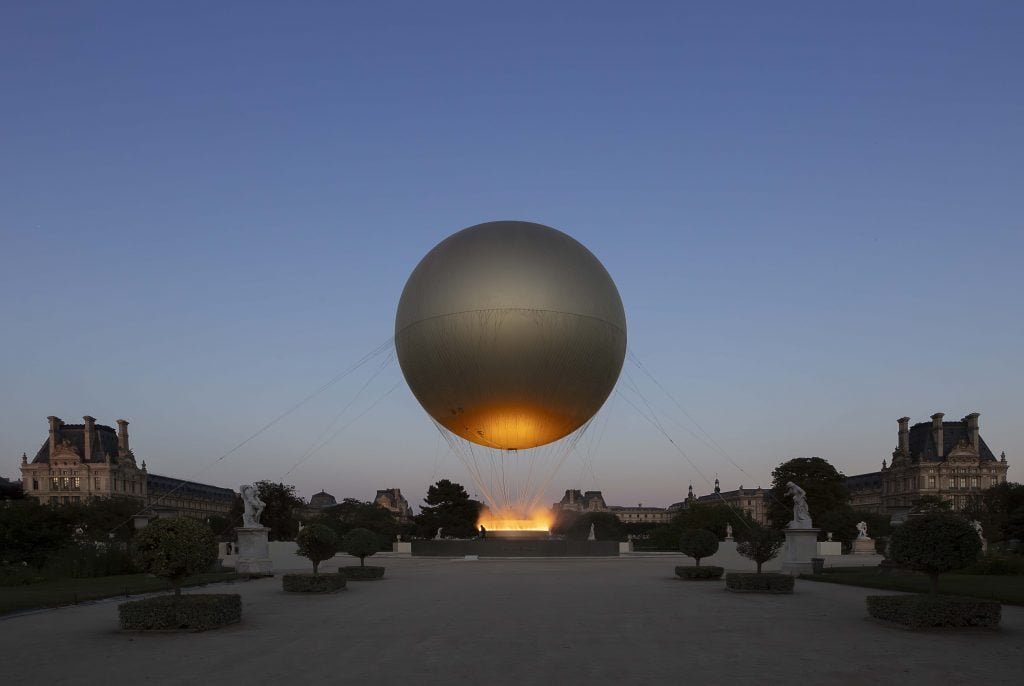 Mathieu Lehanneur's Paris 2024 Olympic Cauldron, with its helium balloon, seen at dusk in the Tuileries garden.