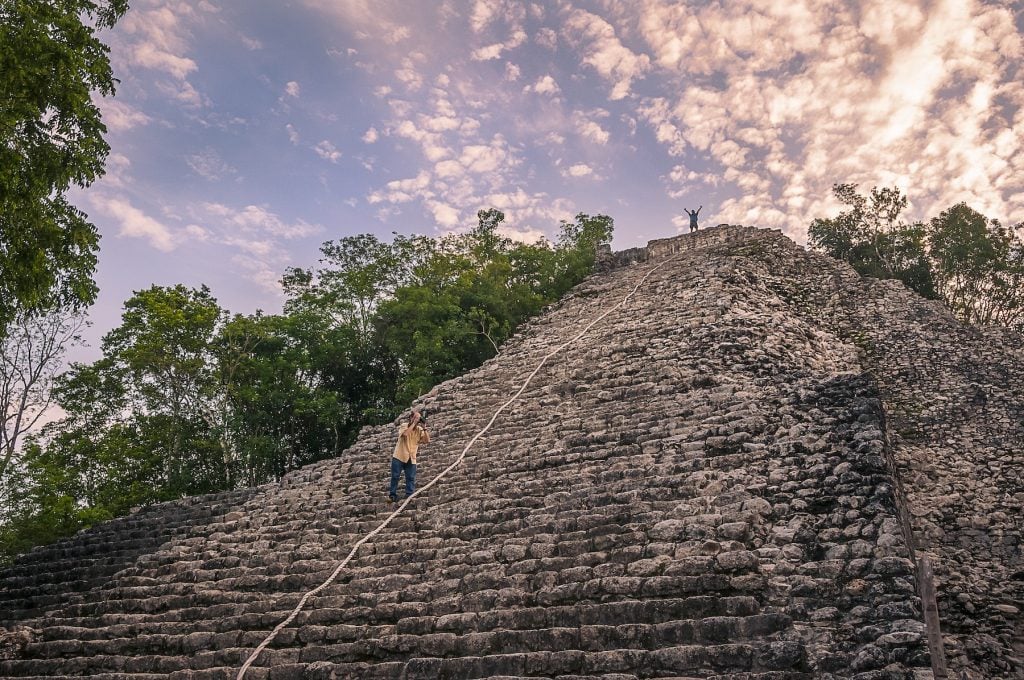 Two tiny human figures on a large pyramid