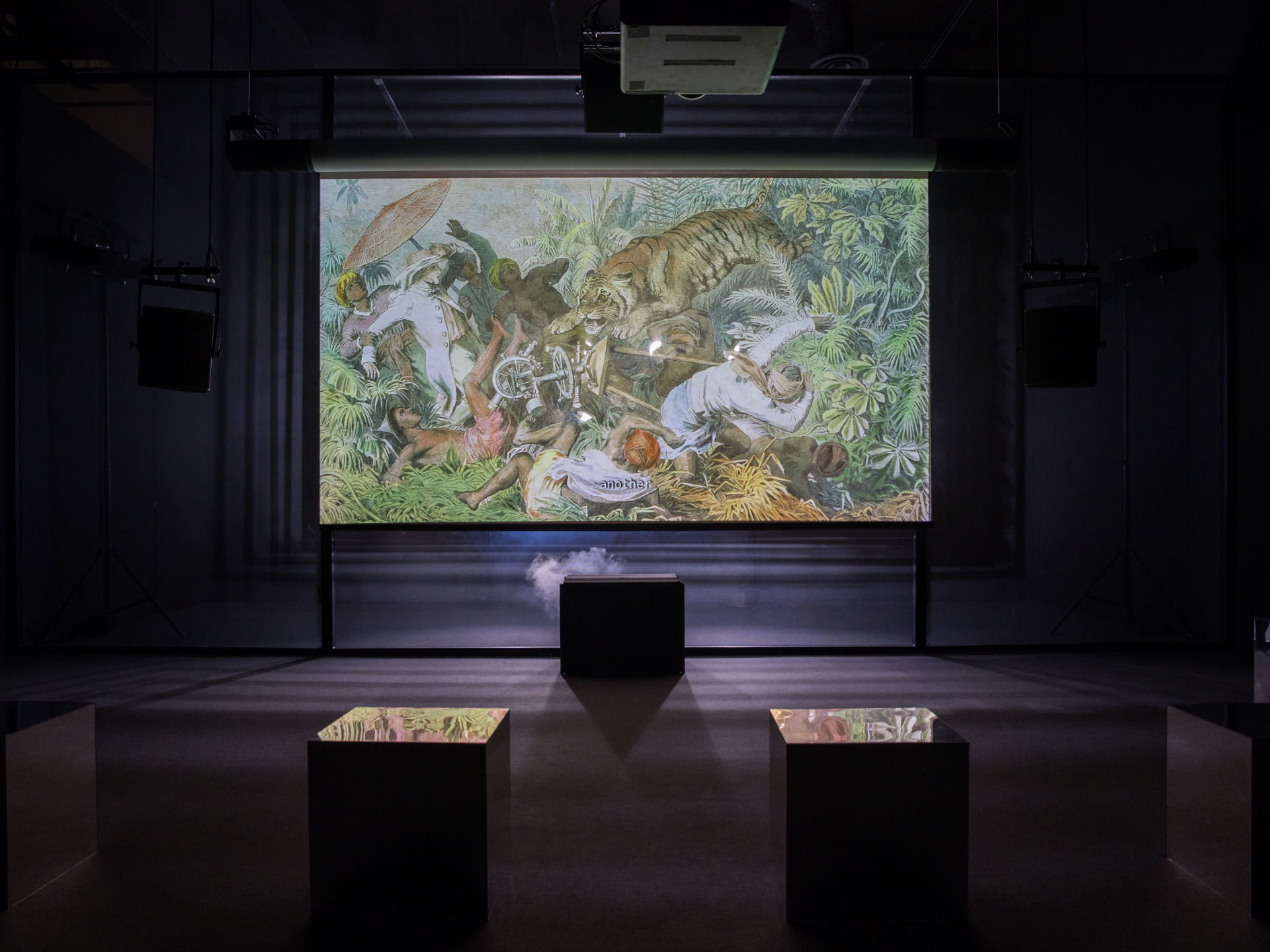 a screen showing an illustration of a tiger amid foliage is seen in a darkened room