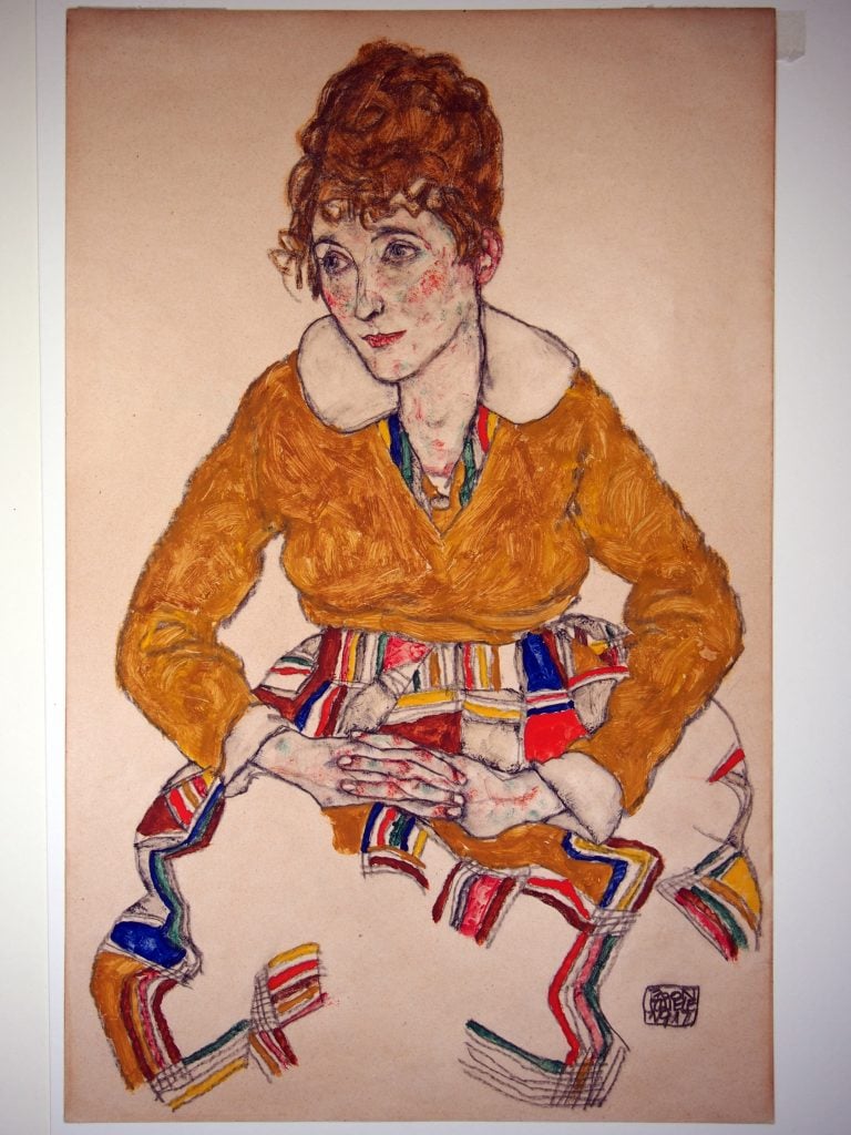 a colorful drawing of a woman with brown hair and a coat and a colorful skirt