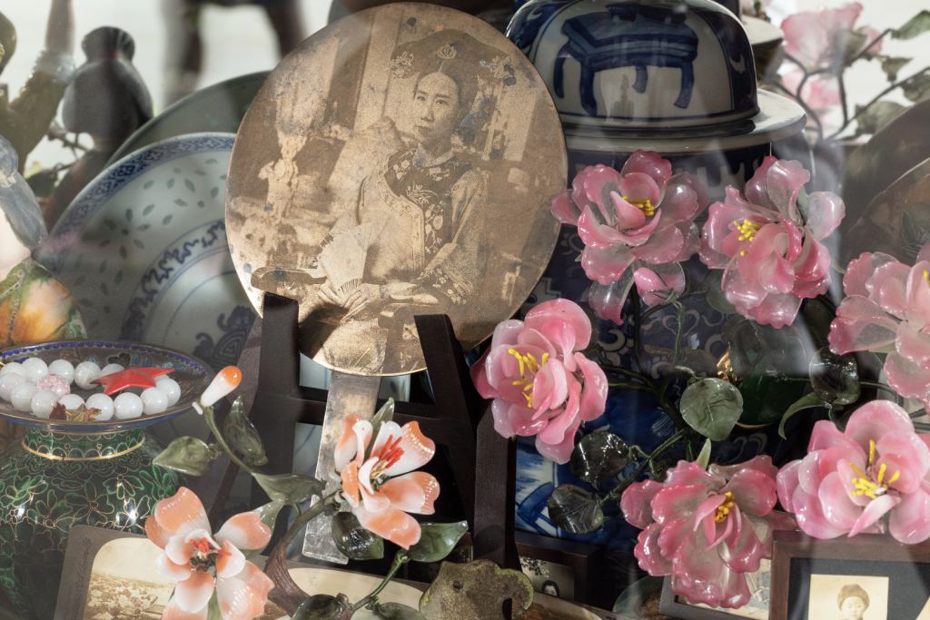 This photo depicts an installation made of ceramic flowers, and an image of a woman dressed in Qing princess costume.