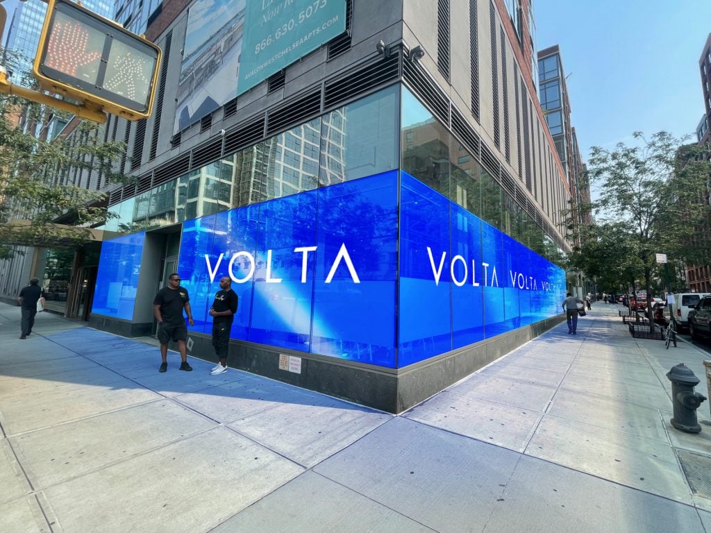 Exterior of the Chelsea Industrial with the blue Volta New York logo wrapping around the inside of the street-facing sidewalk windows.