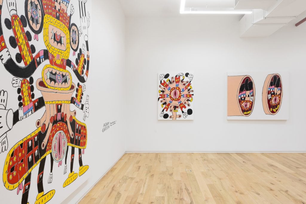 A gallery hung with abstract paintings with bright colors