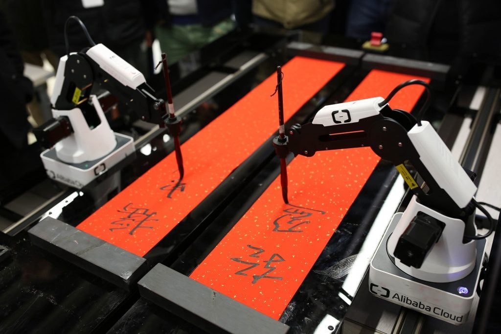 A robot arm writes Chinese characters on a red scroll