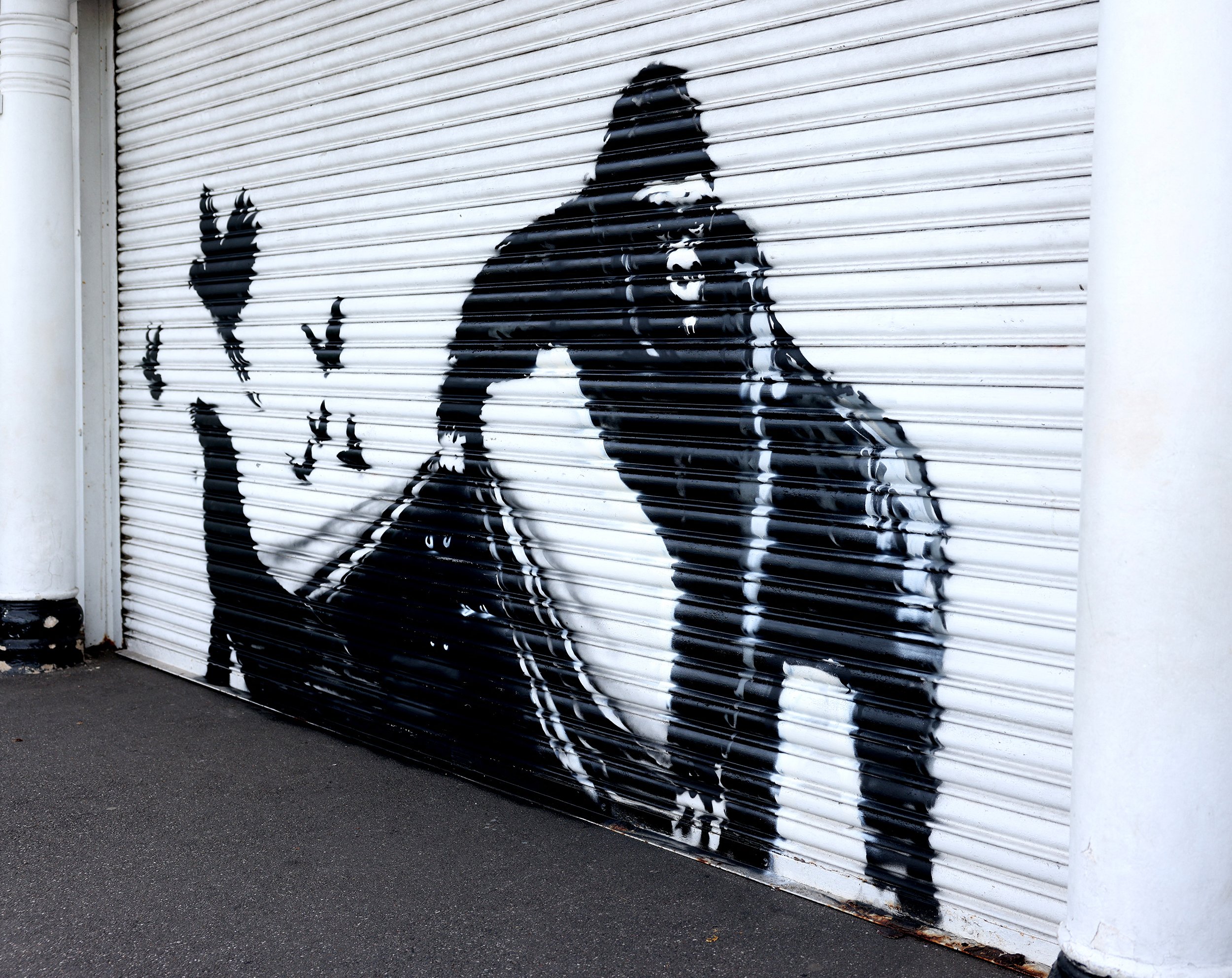 A mural by Banksy depicting a gorilla lifting up a sheet to release animals including birds and a seal