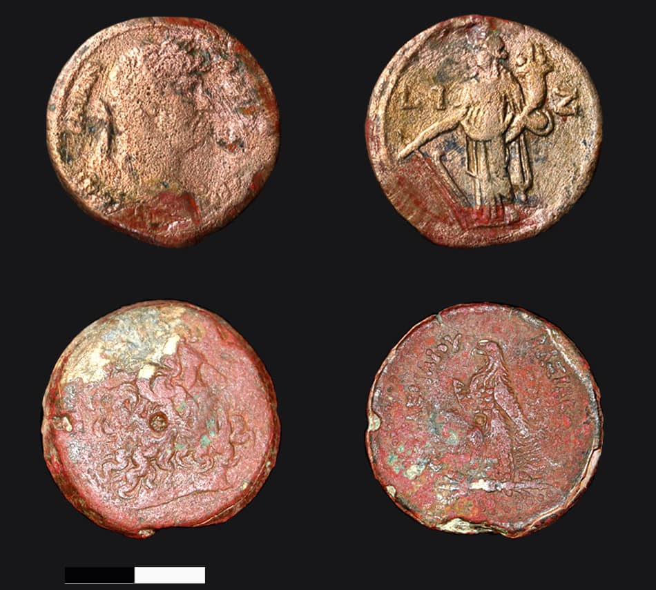 Four coin-shaped relics laid out against a black background