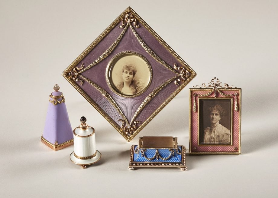 The Fabergé objects from the collection of Brighton and Hove Museum. The two gold-mounted table frames are decorated with rose-pink enamels and applied with lovers knots and laurel leaves emblematic of the Triumph of Love. The women in the pictures are Sophia of Prussia, the Queen of Greece in the purple, and Maria Perugia in the pink. The three objets de luxe are decorated with translucent and matt enamels. The stamp damper is made of silver-gilt and the roller is carved from rock crystal. The gold-mounted gum pots are applied with trails of triumphal laurels and the brush handles set with a cabochon garnet and a moonstone. Credit: Tessa Hallmann / Brighton and Hove Museum