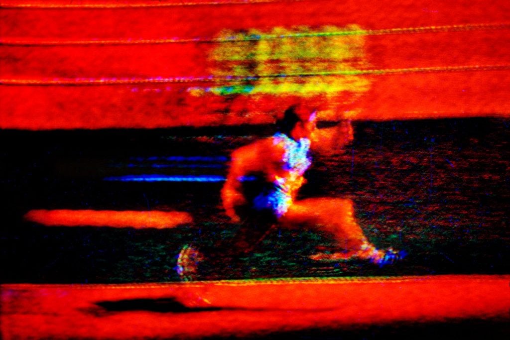 A still shot from an old TV of a runner competing in the 1972 Olympics.