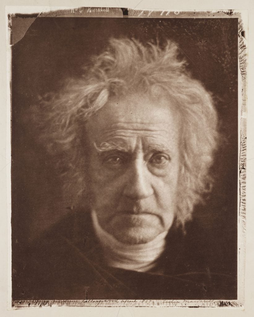 Sepia-toned portrait of inventor John Herschel, depicted as an old man with rumpled white hair