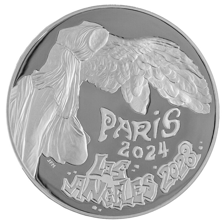 The obverse of the the official LA28 Handover Medallion, designed by mint chief engraver Joseph Menna. The silver coin shows “The Winged Victory of Samothrace” alongside the inscriptions “PARIS 2024” and “LOS ANGELES 2028” done in Art Deco and Graffiti Arts style.