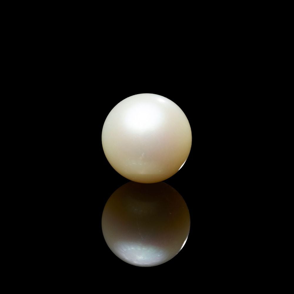 the round white pearl with a black backdrop and its reflection in front.