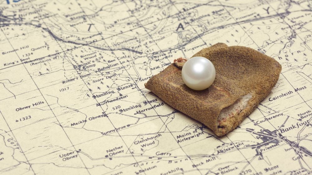 the pearl sits on a map of the Scottish countryside