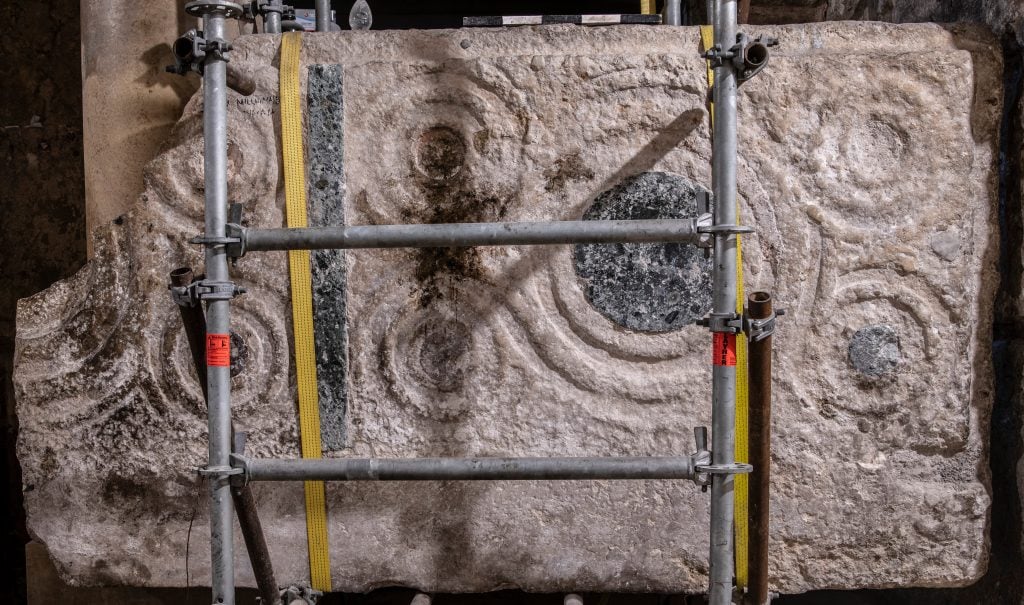 A large stone slab carved with geometric circles