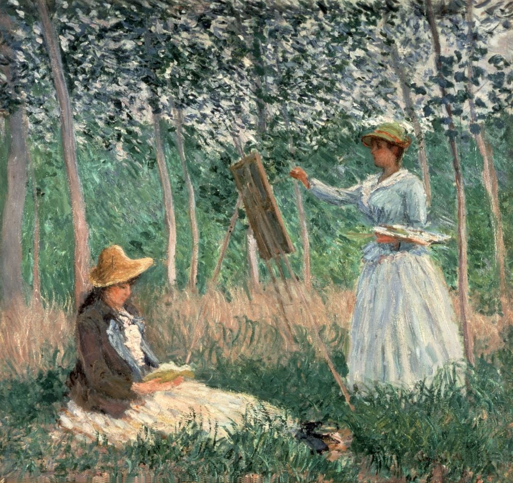 A painting by Monet depicting a young woman in white painting on an easel amongst the woods while another young woman sits on the ground watching on