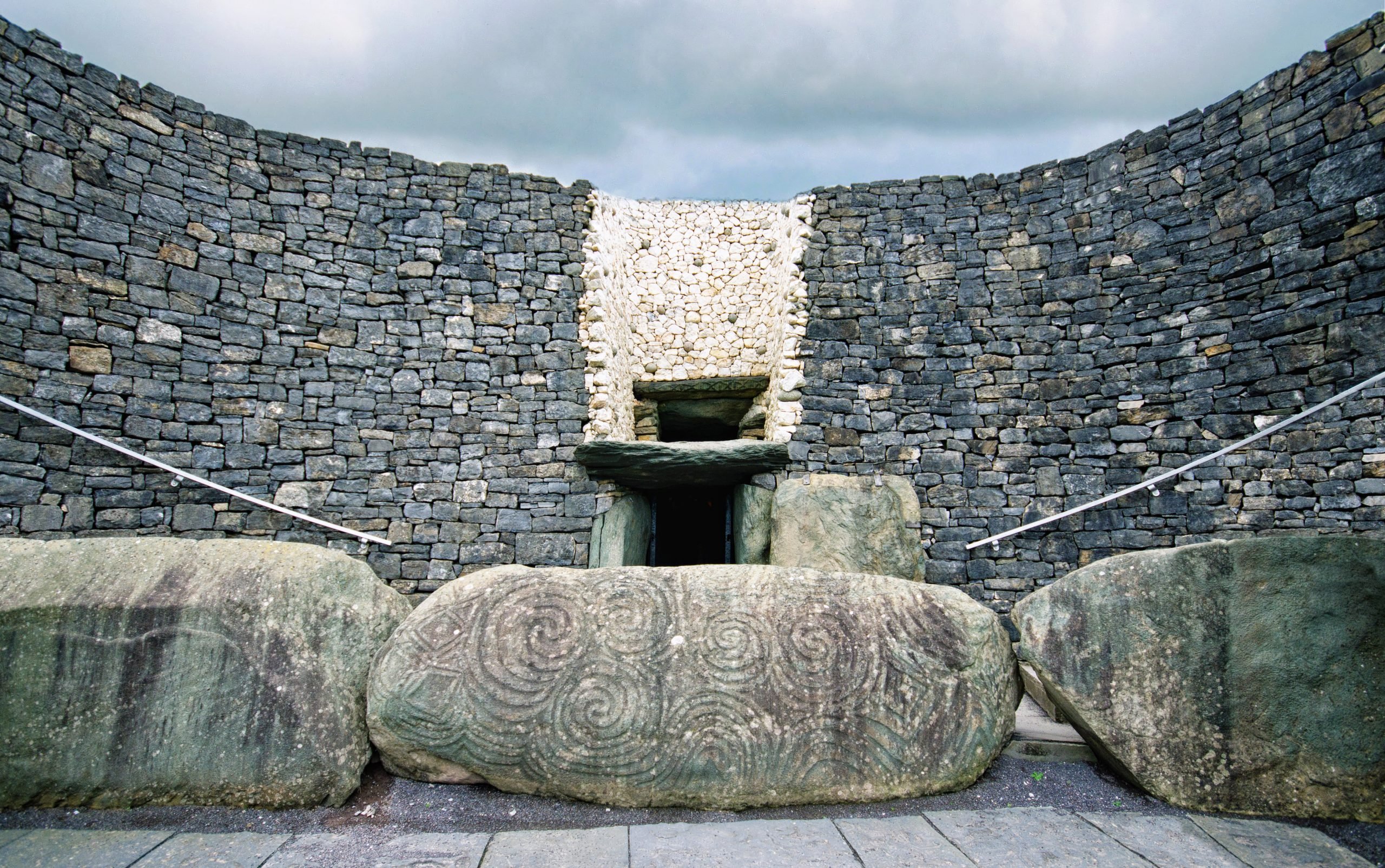 A stone with circular engravings at the entrance to an ancient burial mound