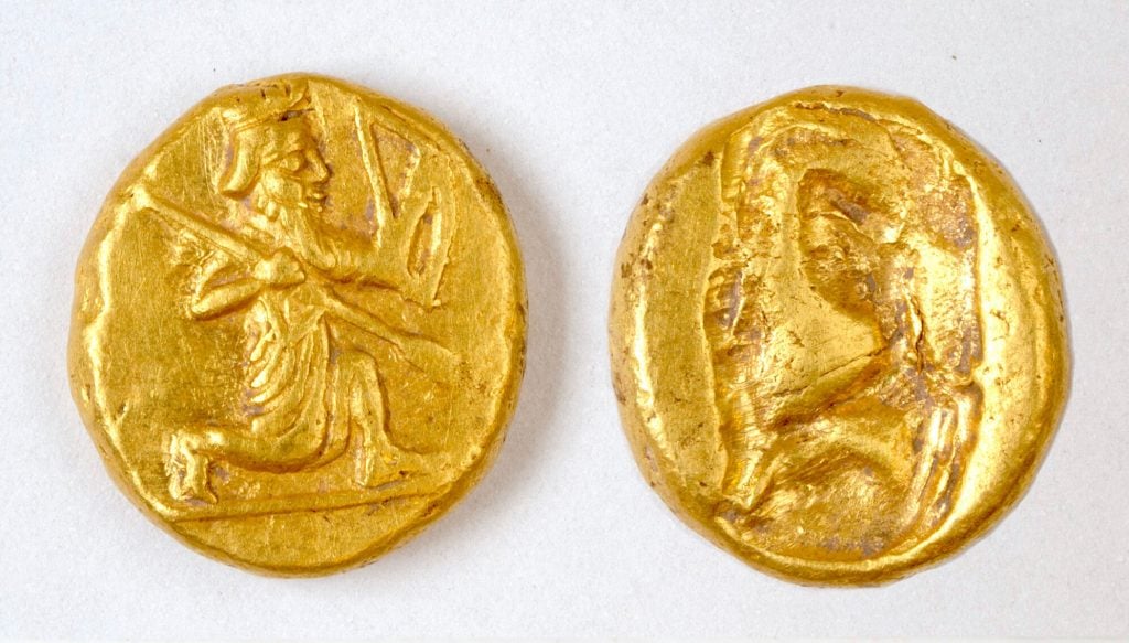 Two ancient Persian gold coins, one depicting a kneeling archer