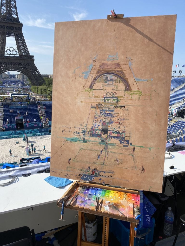 The early stages of Peter Spens's painting of the Olympic beach volleyball tournament, with a view of the Eiffel Tower.